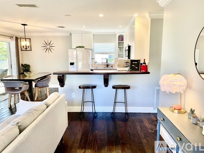 A modern kitchen with a bar area and a dining table.