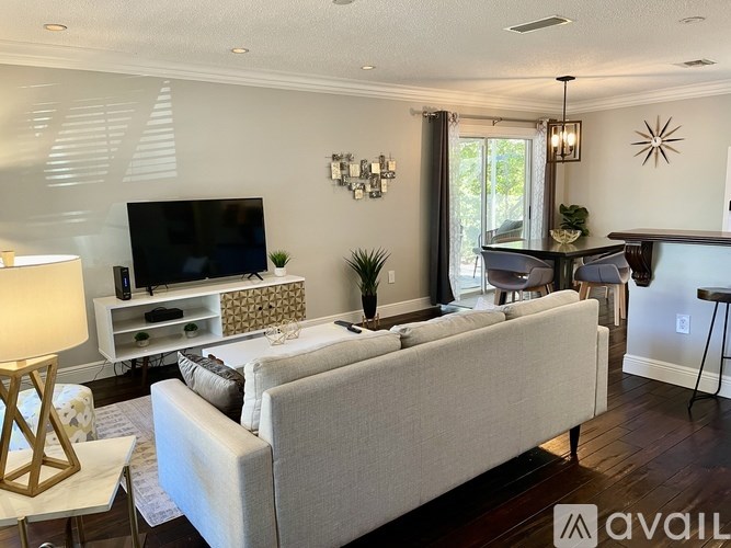 A living room with a white couch, a television, and a fireplace.