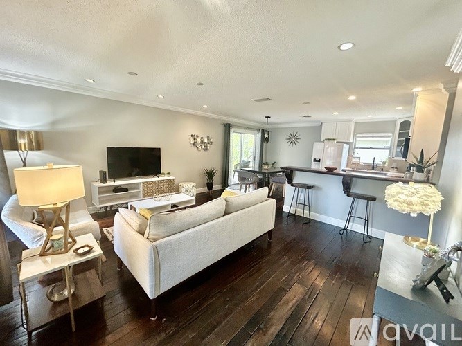 A living room with a white couch and a wooden floor.