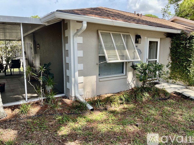 A house with a patio and a window with shutters.