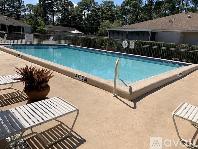 A pool with a fence and a plant in a pot.