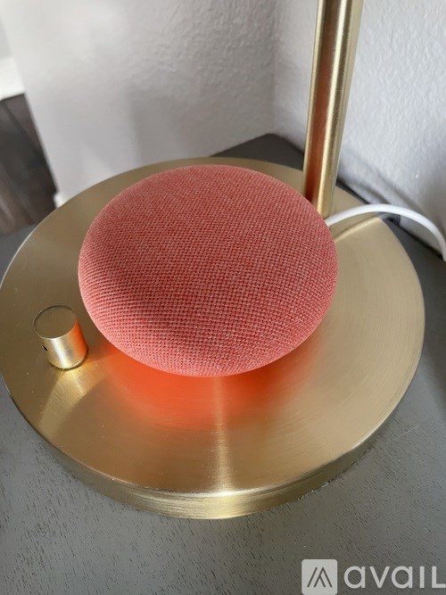A red spherical object is placed on a gold circular base.
