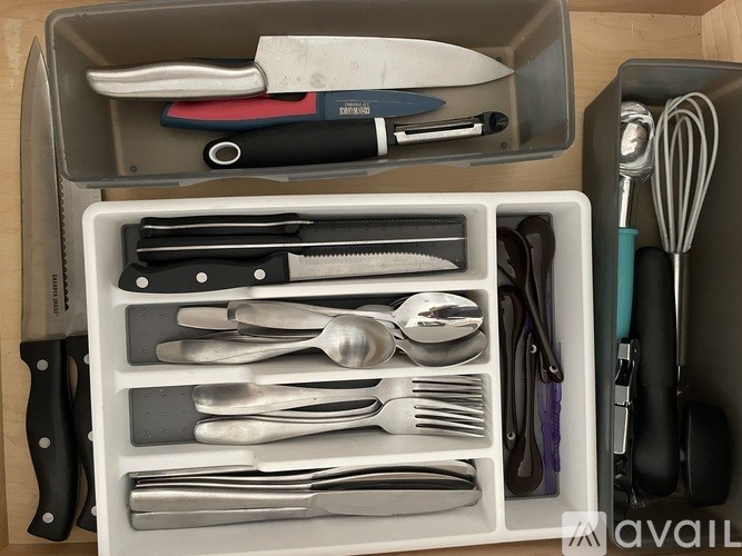 A set of kitchen utensils is organized in a drawer.