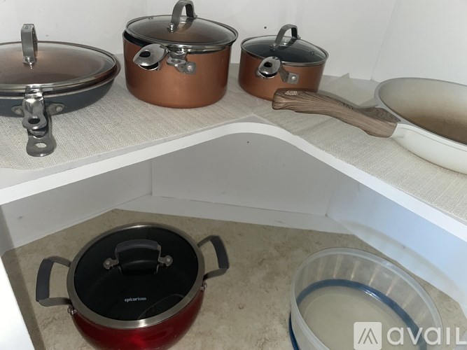 A set of cookware including pots and pans are displayed on a countertop.