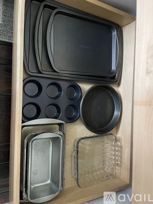 A drawer with a variety of pans and pots.