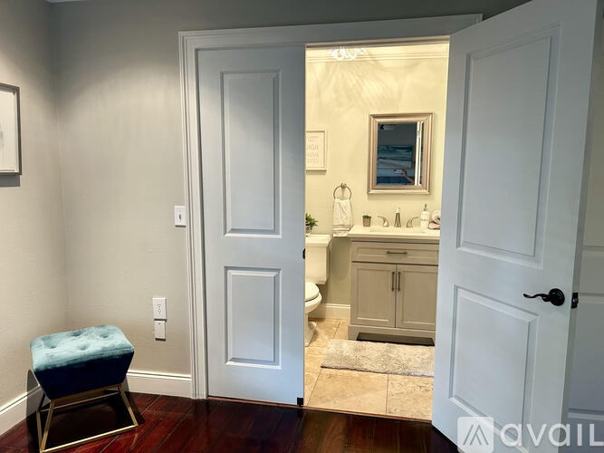 A bathroom with a toilet, sink, and mirror.