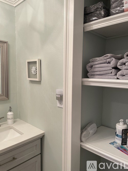 A bathroom with a white sink and towel rack.