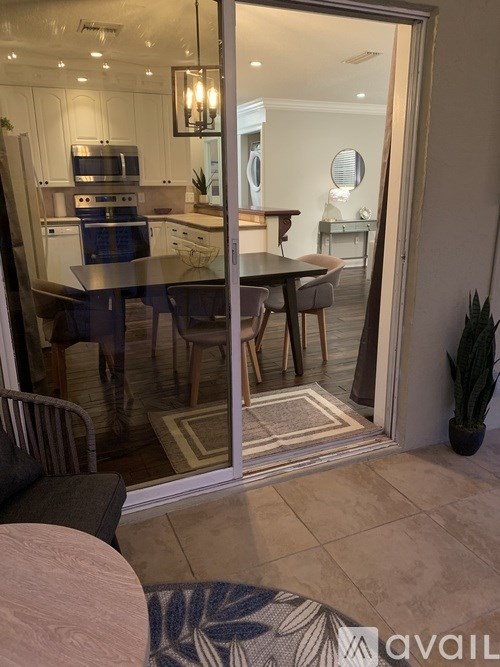 A modern kitchen with a glass door leading to a dining area.