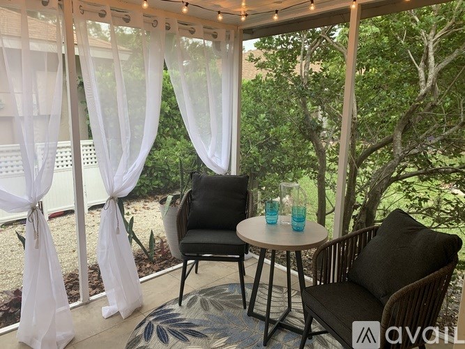 A patio with a table, chairs, and a view of the garden.