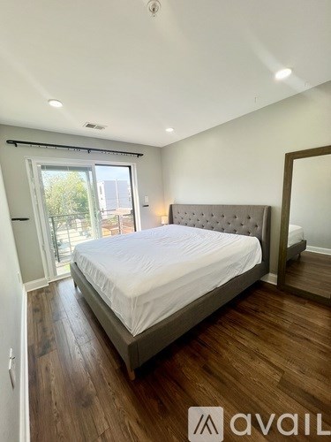 A bedroom with a large bed and wooden floors.