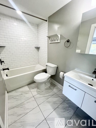 A white bathroom with a tub, toilet and sink.