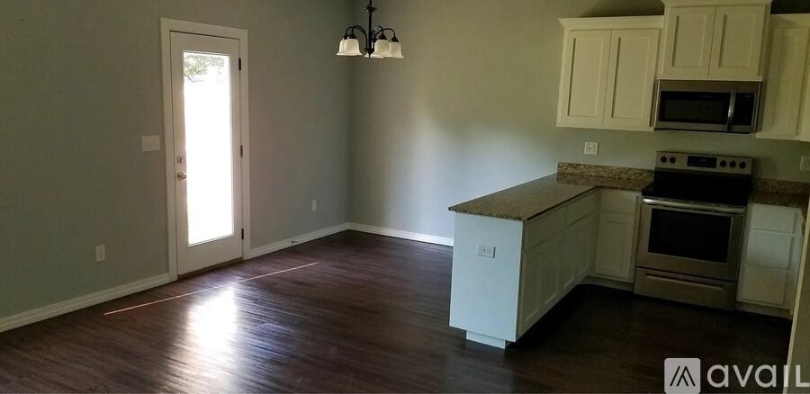 A kitchen with white cabinets and a brown countertop.