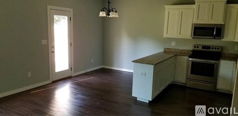 A kitchen with white cabinets and a brown countertop.