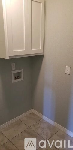 A kitchen with white cabinets and a tiled floor.