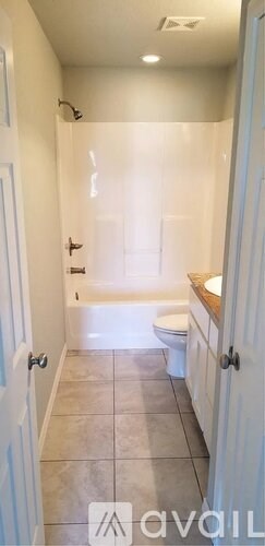 A bathroom with a toilet, sink, and bathtub.