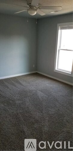 A room with a ceiling fan and a window.