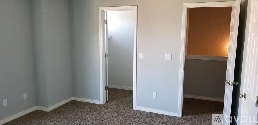 A room with a carpeted floor and a white door.