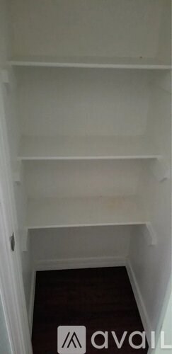 A white shelf with a small black dot on the top left corner.