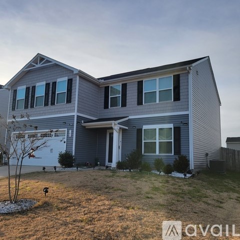 A house with a grey exterior and a white garage door.