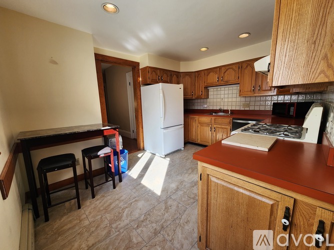 A kitchen with wooden cabinets and a white refrigerator.