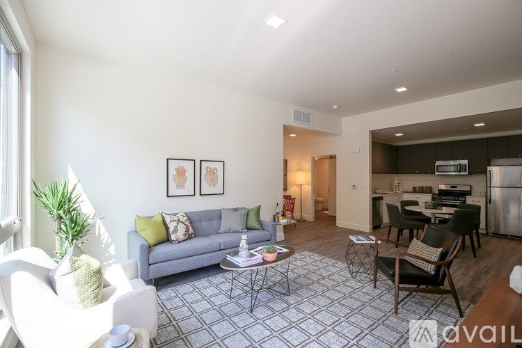 A living room with a grey couch and a grey and white tiled floor.