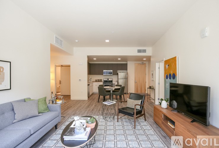 A living room with a grey couch, a coffee table, and a television.