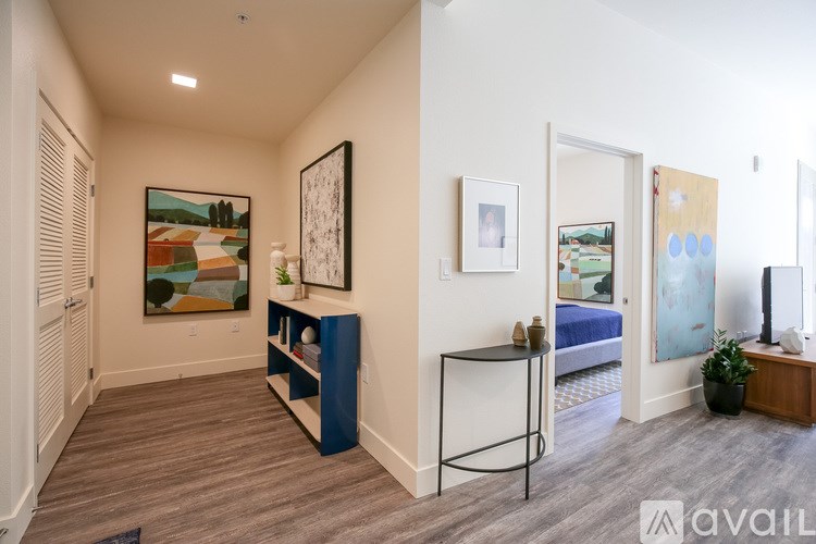 A hallway with a blue console table and a painting on the wall.