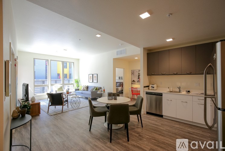 A modern kitchen and living room with a dining table and chairs.
