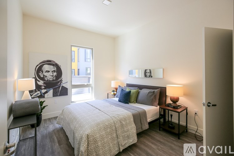 A bedroom with a bed, nightstands, and a picture of an astronaut on the wall.