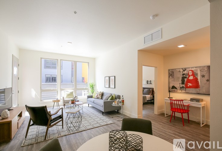 A living room with a red chair and a white table.