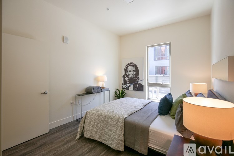 A bedroom with a bed, nightstands, and a window.