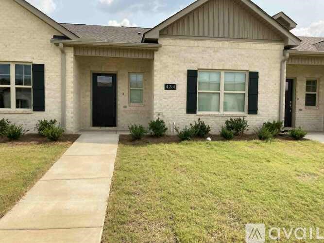 A beige house with a black door and window.