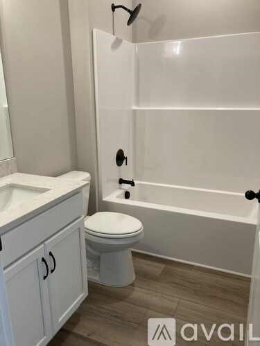 A white toilet sits next to a bathtub in a bathroom.