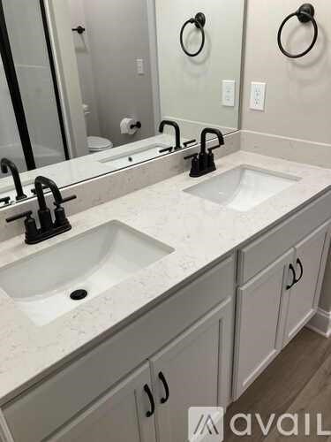 A bathroom with two sinks and a large mirror.