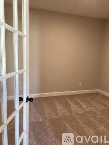 A room with a carpeted floor and a white door.