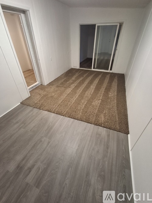 A room with a carpet and wooden flooring.