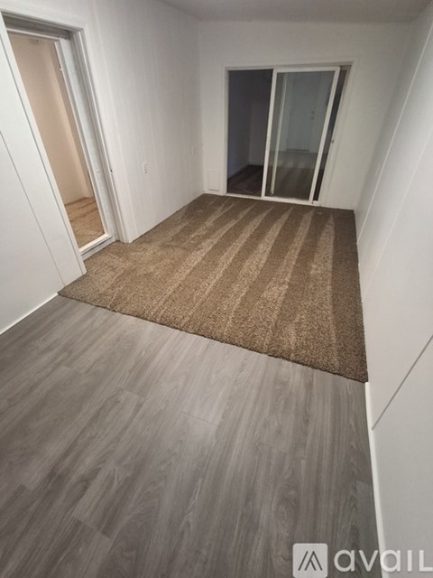 A room with a carpet and wooden flooring.