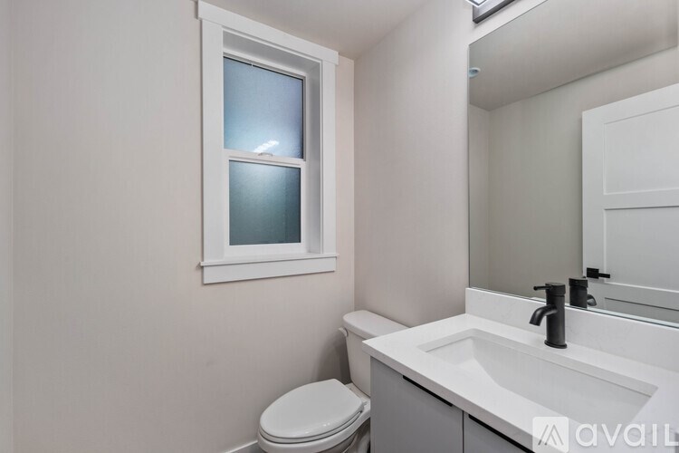 A white toilet sits next to a sink in a bathroom.
