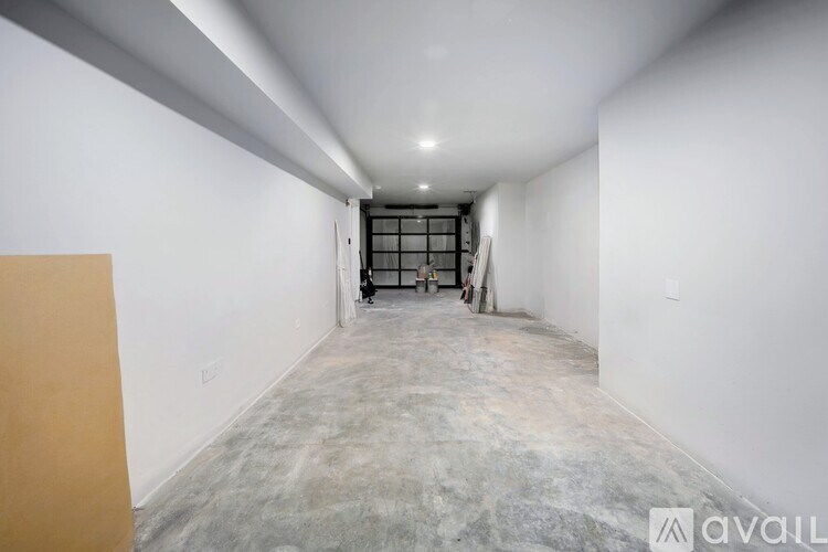 A long, empty hallway with a door at the end.