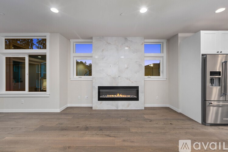 A modern living room with a fireplace and a refrigerator.