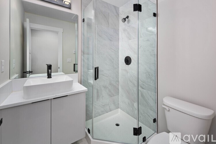 A bathroom with a white sink and a glass shower stall.