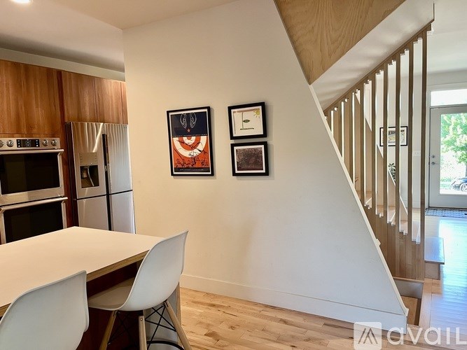 A white dining table with two chairs in a room with a staircase.