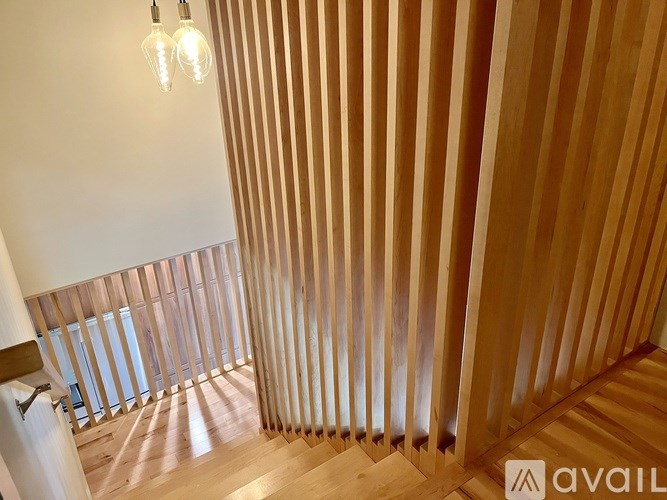 A room with wooden slats on the wall and a light bulb hanging from the ceiling.