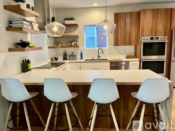 A kitchen with a white countertop and blue chairs.