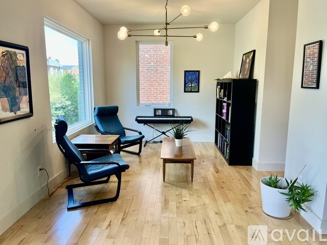 A living room with a black chair and a wooden coffee table.