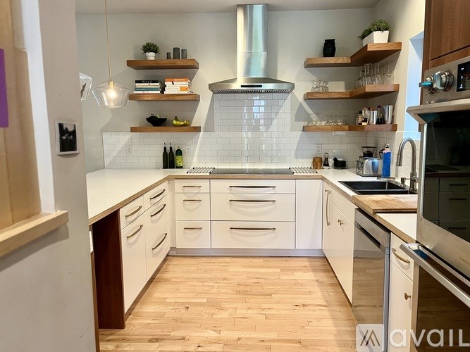 A kitchen with wooden floors and white walls.
