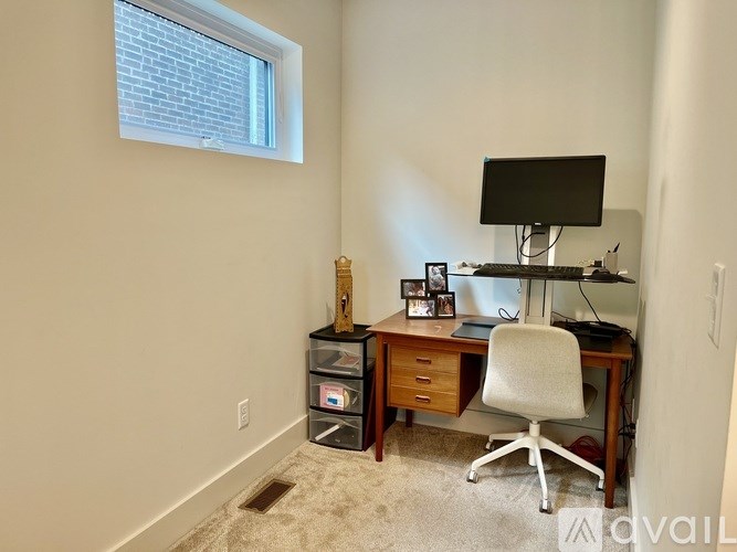 A room with a desk, chair, and a monitor.