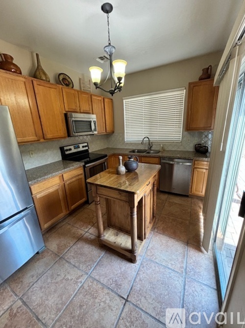 A kitchen with wooden cabinets and a tiled floor.