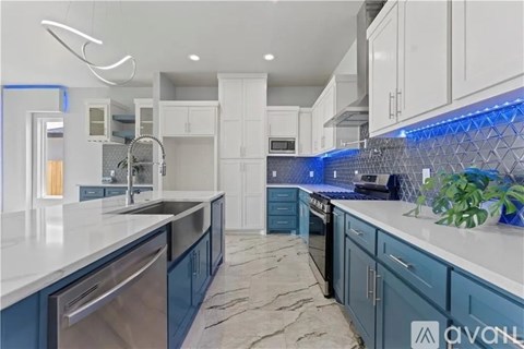 A modern kitchen with blue cabinets and a marble floor.