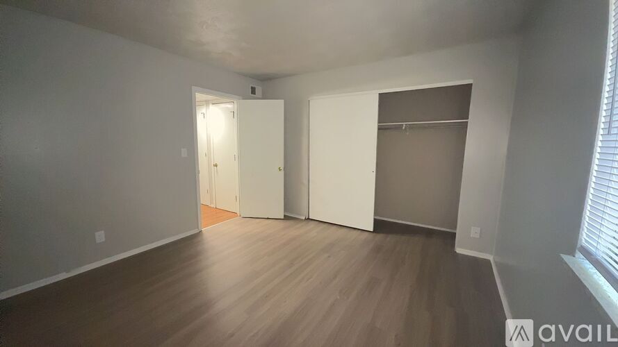 A room with a white door and a window with blinds.